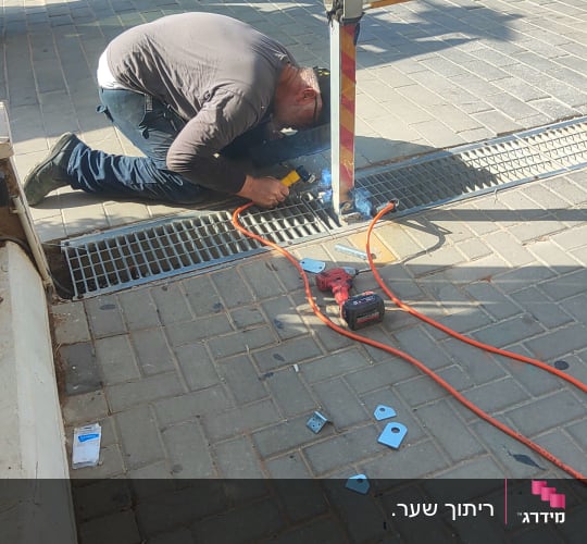 עבודת ריתוך ברזל בשטח בבסיס עמוד מחסום מתכת